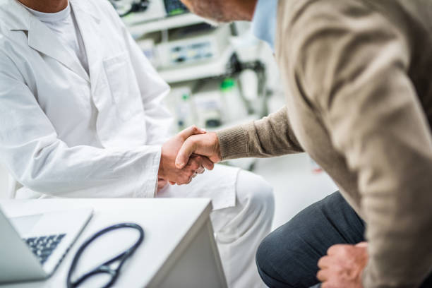 Patient shaking hand with doctor in clinic.